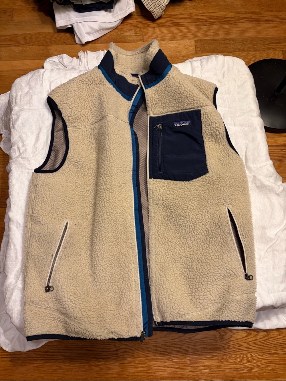 Patagonia Men’s Cream Sherpa Vest with Navy Chest Pocket and Blue Trim